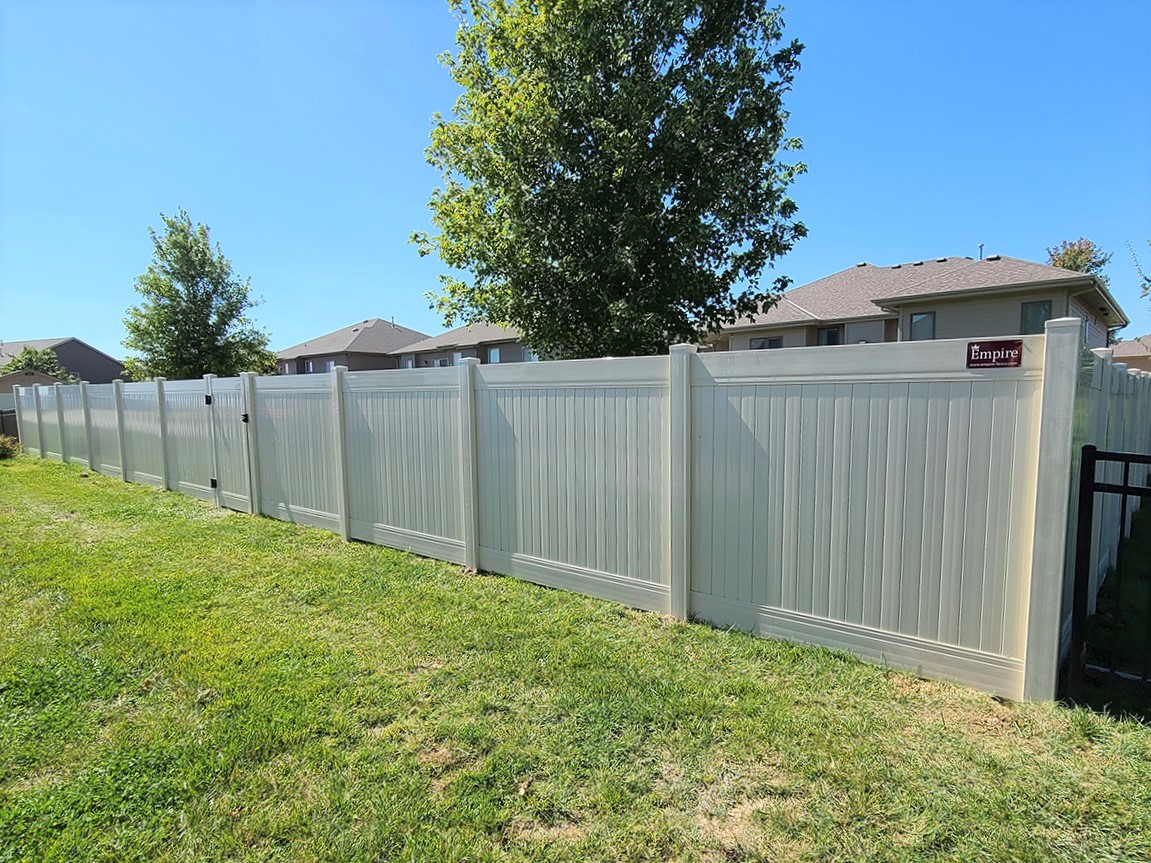 Photo of a tan vinyl privacy fence in a residential community